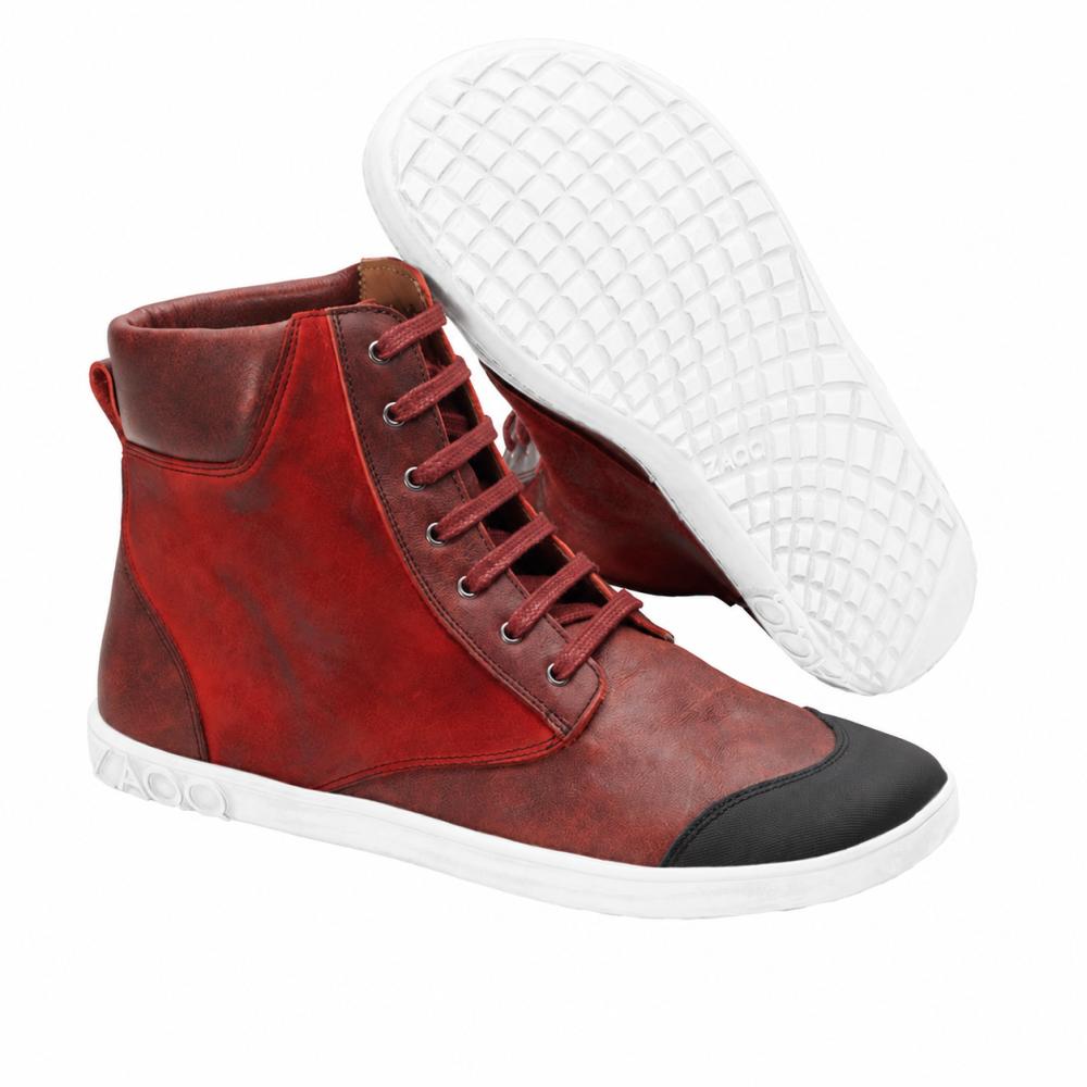 Wir präsentieren den CHICAQO Red von ZAQQ: Diese stylischen High-Top-Sneakers in leuchtendem Rot sind aus hochwertigem Nappa- und Veloursleder gefertigt. Sie haben eine glatte weiße Sohle und eine auffällige schwarze Zehenkappe. Ein Schuh steht aufrecht, während der andere geneigt ist und seine strukturierte, flexible Sohle zur Schau stellt.