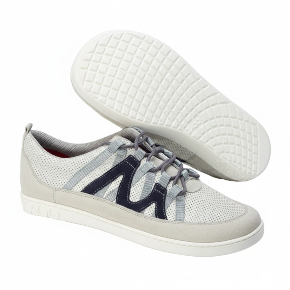 Ein Paar lässige ZAQQ DRAQE White Grey Sneaker mit strukturierter Sohle. Diese stylischen Schuhe haben marineblaue Akzente an den Seiten und hellgraue Schnürsenkel. Ein Schuh ist aufrecht abgebildet, während der andere das aufwendige Sohlenmuster zeigt, was ihr modisches Design unterstreicht.