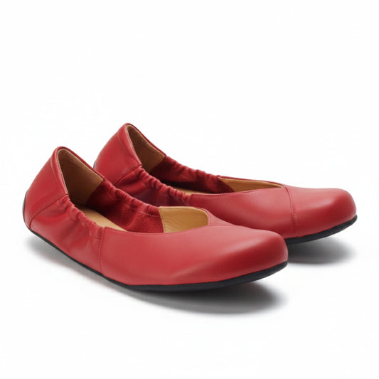Die Ballerinas MAIQA Red von ZAQQ sind aus weichem Nappaleder gefertigt und verfügen über elastische Seitenteile für einen bequemen Sitz. Ihr minimalistisches Design mit schwarzer Sohle kommt vor einem schlichten weißen Hintergrund elegant zur Geltung.